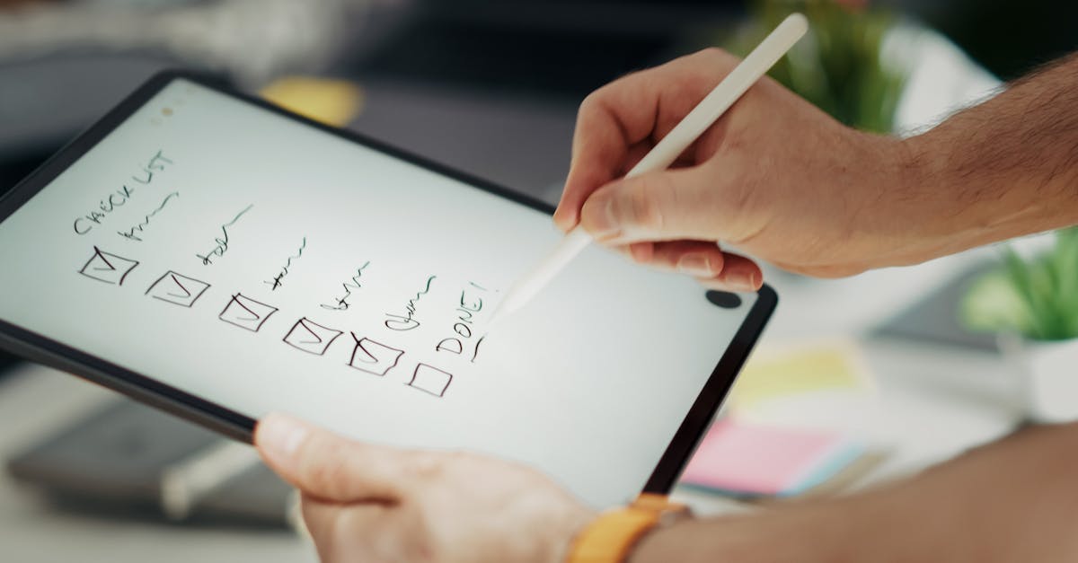 Close-up of a hand writing on a digital checklist using a stylus on a tablet, enhancing productivity.